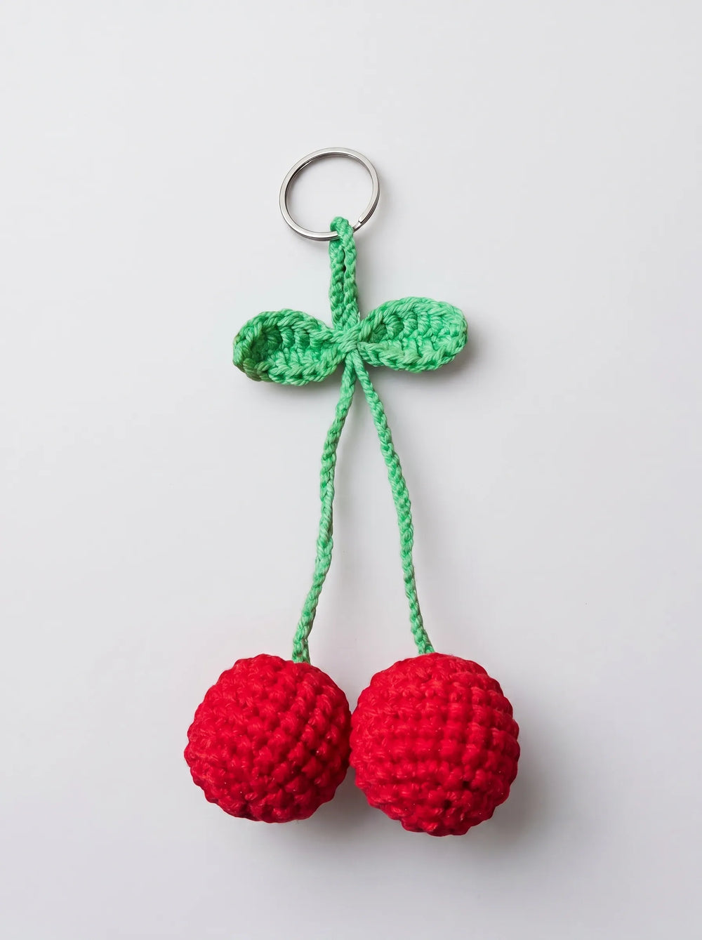 Close-up of handmade crochet cherry keychain showing stuffed red spheres and green leaf detail - WestStyle Pakistan