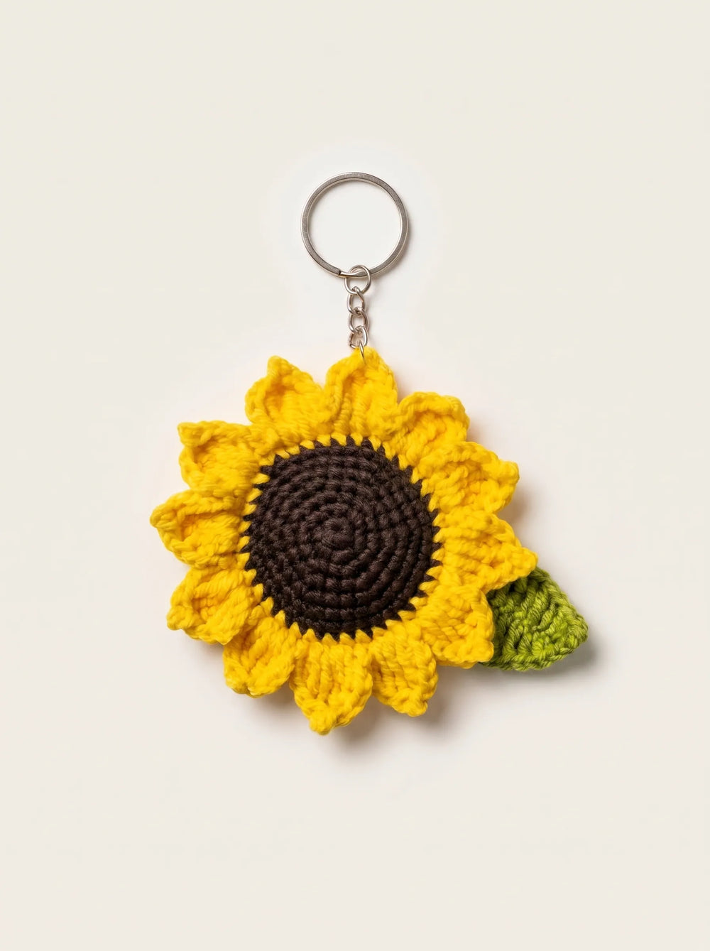 Handmade yellow crochet sunflower keychain with dark brown centre and green leaf - bag charm for girls by WestStyle Pakistan