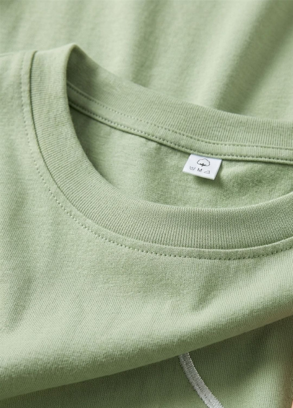 Close-up of a green shirt with a brand label on the collar.