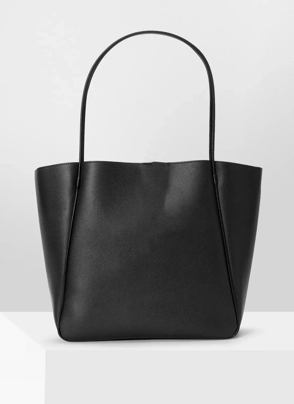 Black spacious PU leather tote bag for university girls placed in white studio space - WestStyle