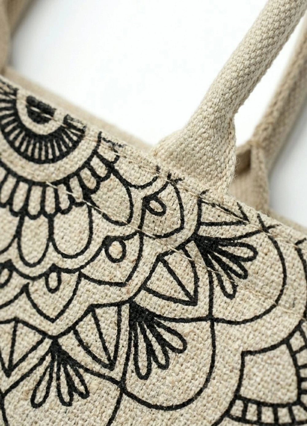 Beige tote bag with black floral embroidery on a white background