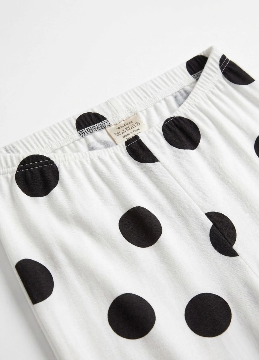 White dress with black polka dots and a visible brand label on a white background