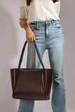 Girl holding a Brown Large tote bag made from PU leather in her hand in gray studio - WestStyle