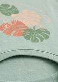 Close-up of a green sweatshirt with tropical leaf patterns.