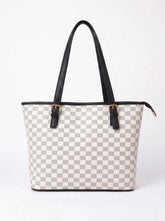A tote bag with a light gray and white checkerboard pattern, black leather handles, and gold-tone buckle details, shown against a plain white background.