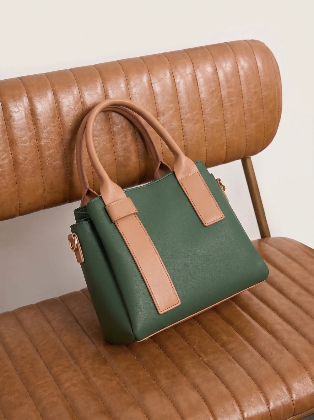 WestStyle Roma forest green shoulder bag with tan contrast panels and rose-gold hardware on leather chair trendy shoulder bag for women Pakistan