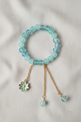 Professional flat lay of aqua bracelet on linen