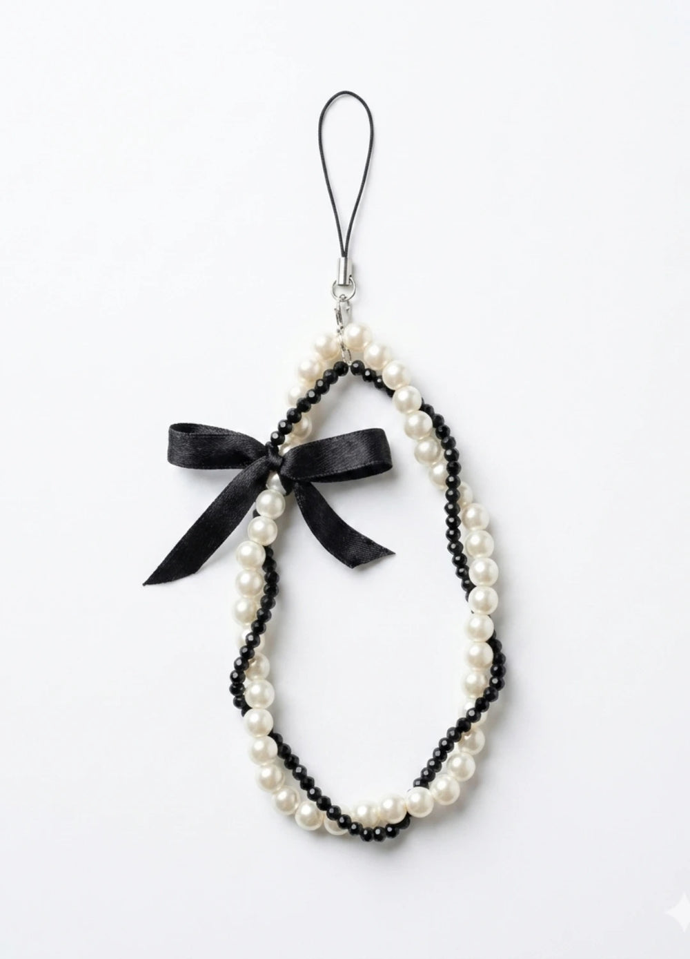 Pearl necklace with a black bow on a white background