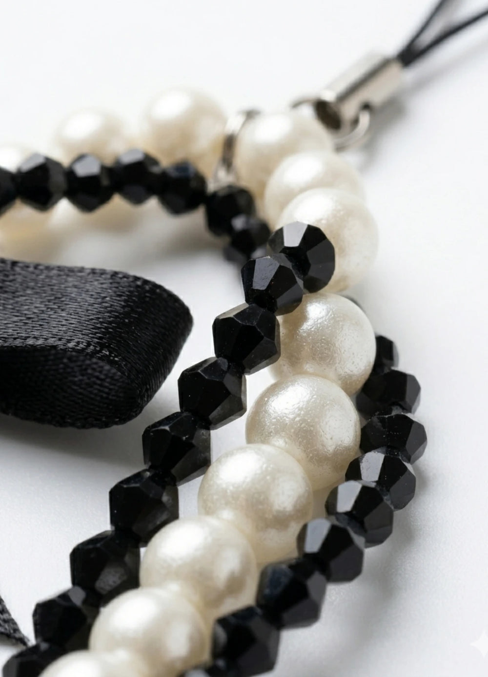 Pearl and black beaded bracelet on a white background