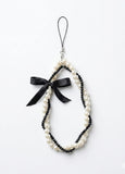 Pearl necklace with a black bow on a white background