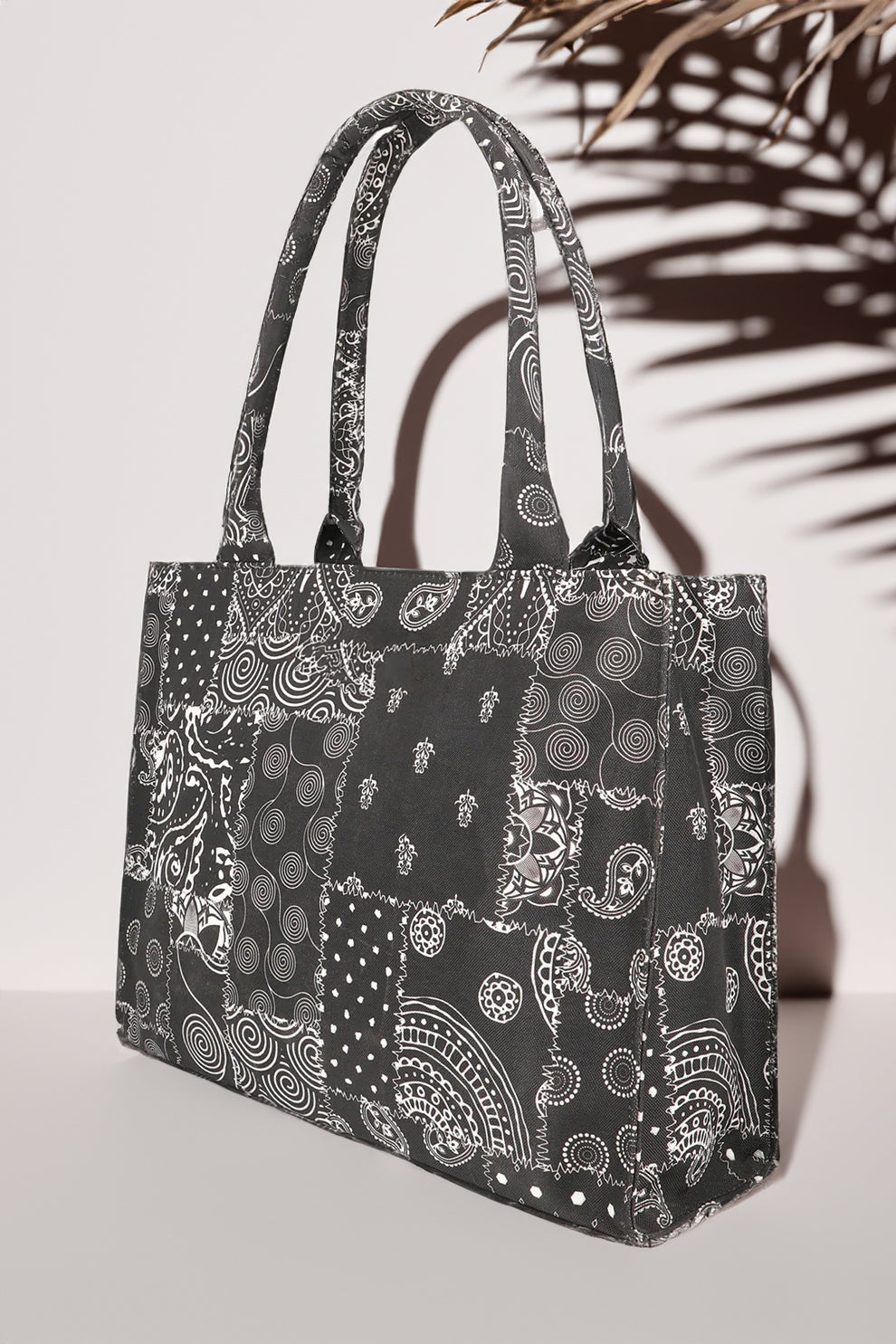 Black tote bag with white patterns on a light gray background