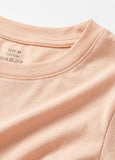 Close-up of a pink t-shirt with size and material labels.