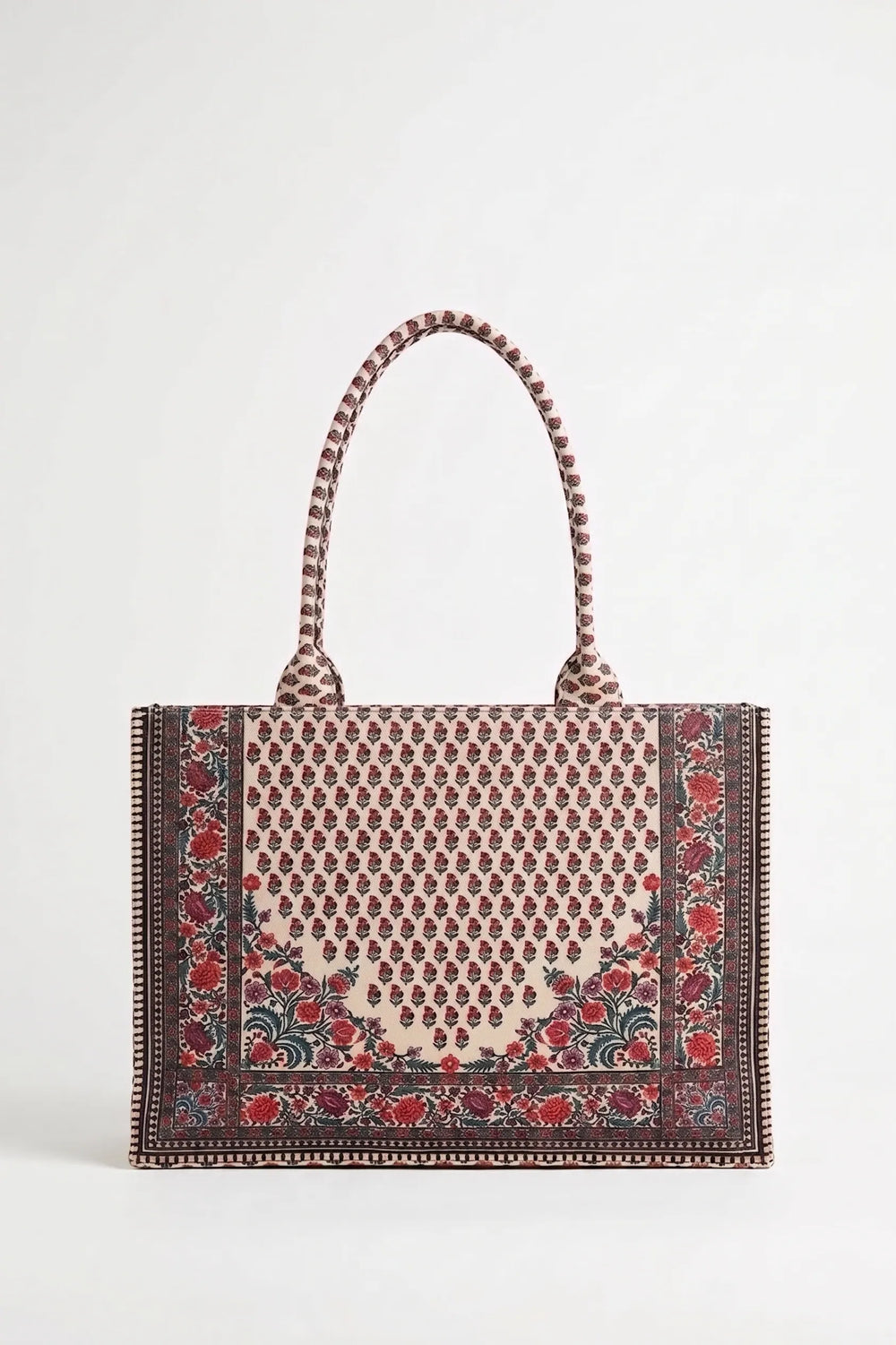 A structured tote bag with a woven pattern featuring a central beige and brown geometric motif, red floral accents, and a dark brown border, complete with braided shoulder straps, shown against a plain light gray background.