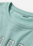 Close-up of a light green t-shirt with text and pixelated design on a white background