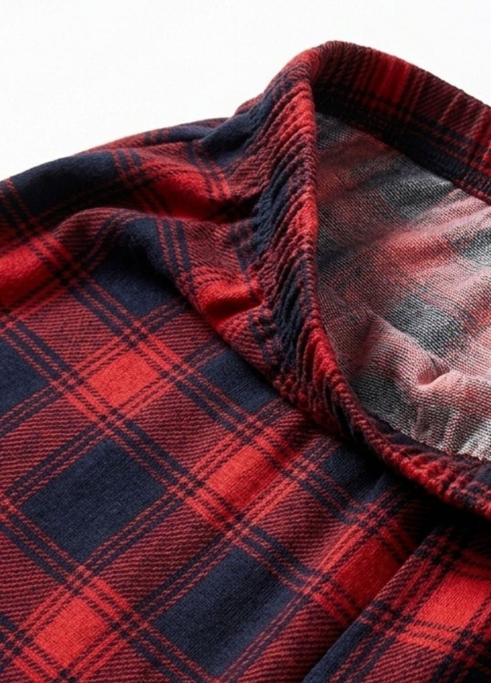 Close-up of red and navy plaid fabric with a textured edge.