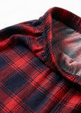 Close-up of red and navy plaid fabric with a textured edge.