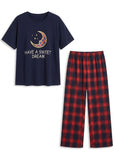 Navy t-shirt with moon and stars design and red plaid pants on a white background