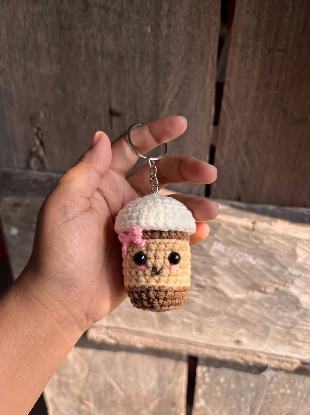 Close-up of kawaii crochet coffee cup keychain showing pink flower detail and black bead eyes - WestStyle