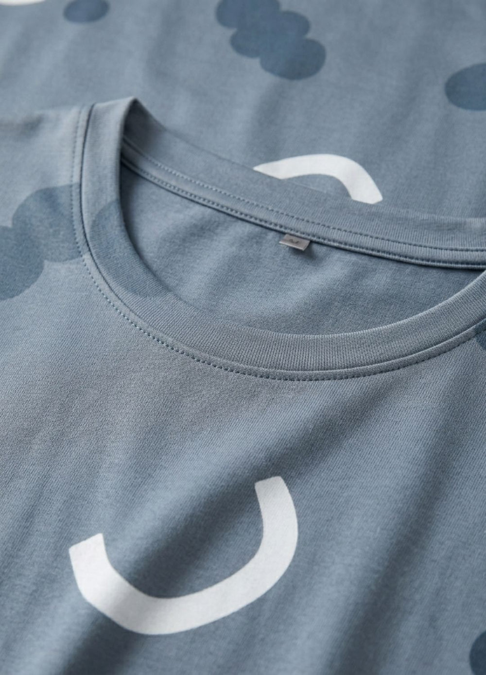 Close-up of a blue shirt with white smiley face patterns