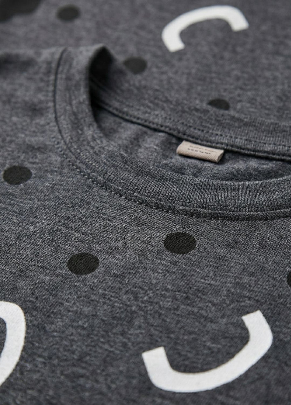 Gray t-shirt with smiley face design and visible brand label.