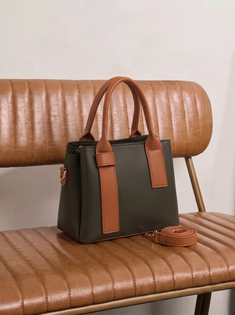 WestStyle Roma dark shoulder bag with tan contrast panels and gold hardware on leather chair classy shoulder bag for women Pakistan