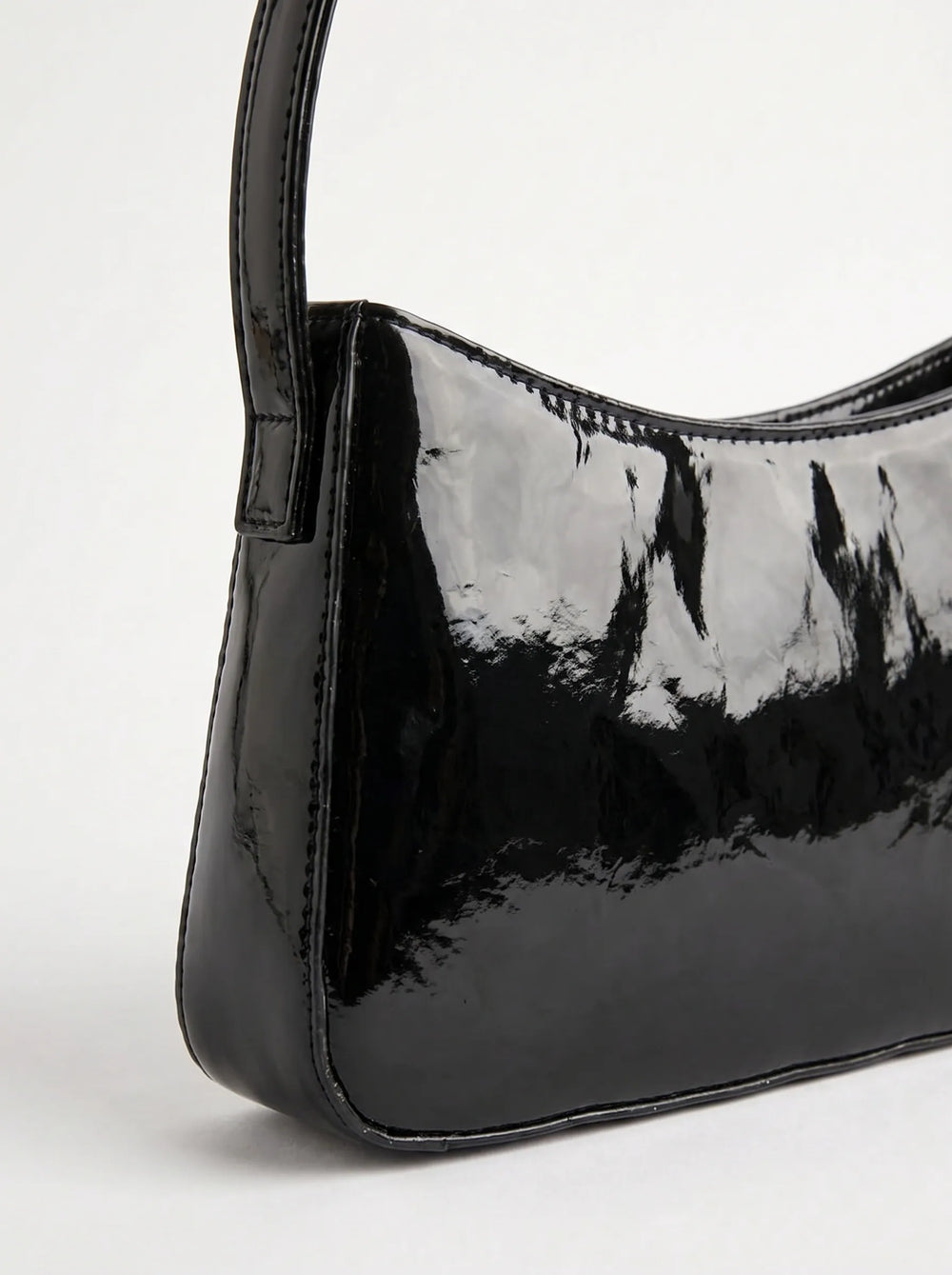 Close-up of high-gloss black patent surface on WestStyle Shine Cherry baguette bag showing mirror finish shiny ladies bag Pakistan