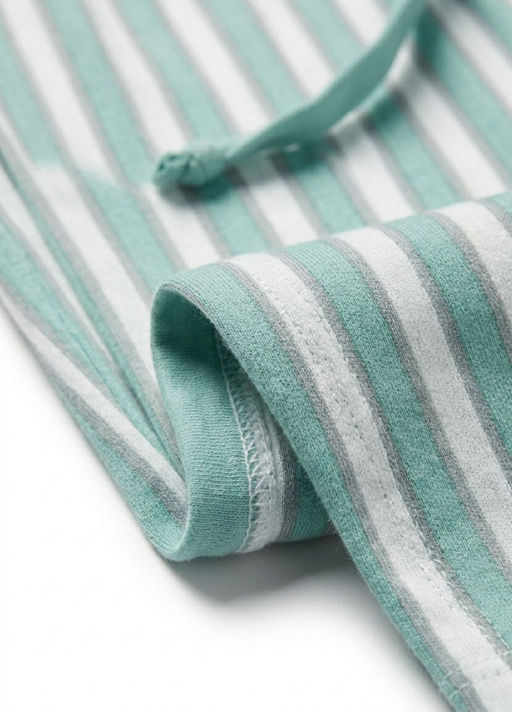 Close-up of a green and white striped fabric with a knot on a white background