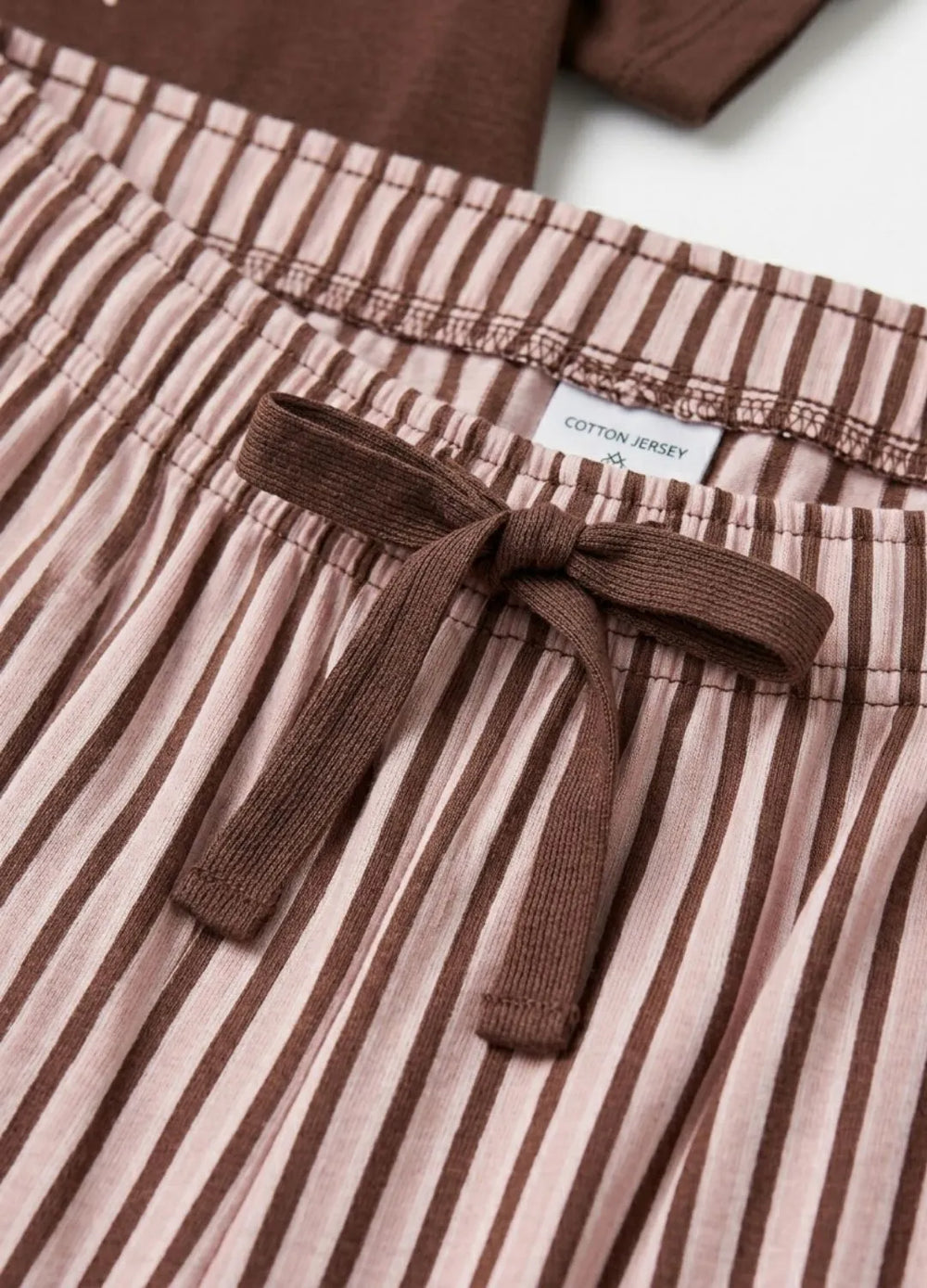 Brown and beige striped pants with a tie detail and 'Cotton Jersey' label.